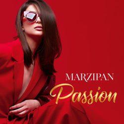 Woman in a sunglasses and red suit is sitting, on the front of the photo is the logotype: Marzipan Passion