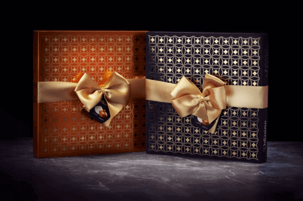 Packages of Delissimo Almond & Hazelnut pralines from Vobro in orange and black graphic design with gold bows