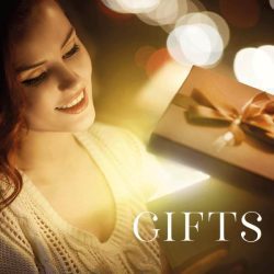 Happy woman in a white sweater looks inside of glowing gift box, on the front of the photo is the text: Gifts