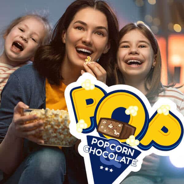 Kobieta z dwoma córkami ogląda film i zajada się popcornem, na przodzie widnieje logo POP Popcorn & Chocolate