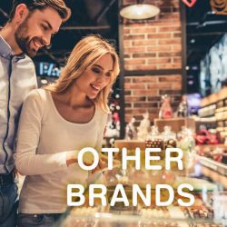 Blond woman in a white blouse and man in the white shirt look at wide range of sweets, on the front of the photo is the text: Other brands