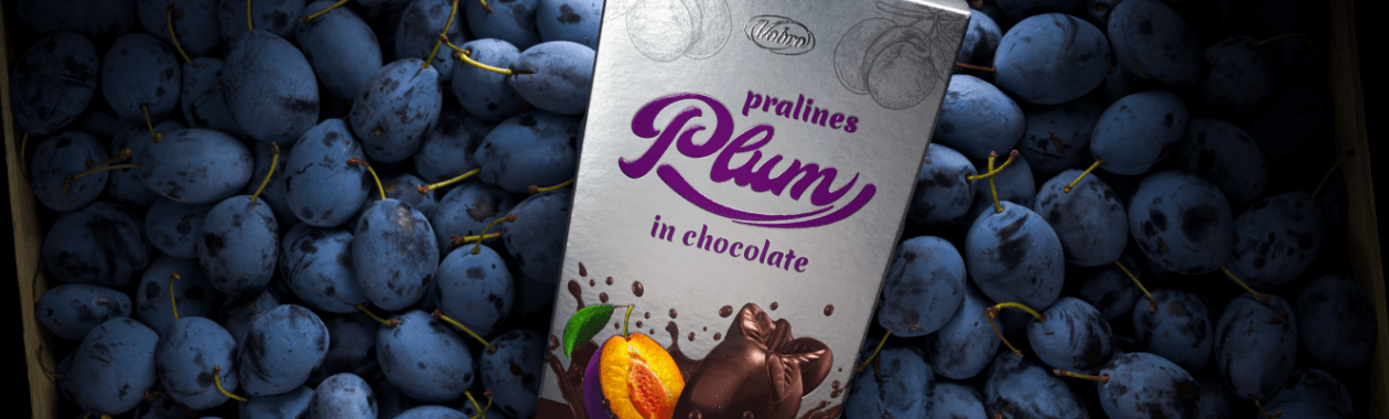 Pralines Plum in Chocolate package on top of the plums